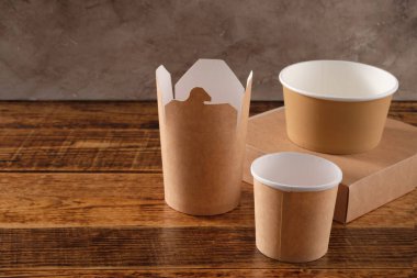 Sokak fast food bardakları, tabaklar ve konteynırlar. Ahşap arka planda çevre dostu gıda ambalajı. Uzayı kopyala Doğanın taşınması ve geri dönüşüm kavramı.