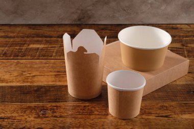 Sokak fast food bardakları, tabaklar ve konteynırlar. Ahşap arka planda çevre dostu gıda ambalajı. Uzayı kopyala Doğanın taşınması ve geri dönüşüm kavramı.