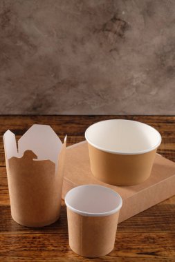 Sokak fast food bardakları, tabaklar ve konteynırlar. Ahşap arka planda çevre dostu gıda ambalajı. Uzayı kopyala Doğanın taşınması ve geri dönüşüm kavramı.