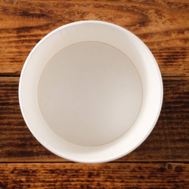 Tahta arka planda izole edilmiş büyük kahverengi kağıt tabak. Çevre dostu tek kullanımlık yiyecek ambalajı. Doğanın korunması ve geri dönüşüm kavramı. Boşluğu kopyala.