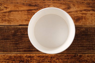 Tahta arka planda izole edilmiş büyük kahverengi kağıt tabak. Çevre dostu tek kullanımlık yiyecek ambalajı. Doğanın korunması ve geri dönüşüm kavramı. Boşluğu kopyala.