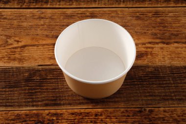 Tahta arka planda izole edilmiş büyük kahverengi kağıt tabak. Çevre dostu tek kullanımlık yiyecek ambalajı. Doğanın korunması ve geri dönüşüm kavramı. Boşluğu kopyala.