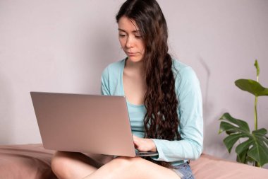 Sosyal uzaklık ve izolasyon kavramı. Evden internete uzaktan bağlanarak çalışmak. Genç bir kadın evde bilgisayarla çalışıyor. Karantina.