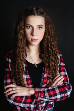 Güzel ince kıvırcık genç kadın genç kız, kırmızı kareli gömlek ve dar bir kot poz siyah arka plan üzerine izole stüdyo portre. Detaylı rötuş