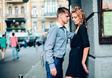 moda aşk hikayesi güzel genç kadın ve beyaz adam modeli sarışın, ayakta poz, mükemmel makyaj ve saç, siyah elbise, Klasik takım, poz, rötuş, vintage renkler ile