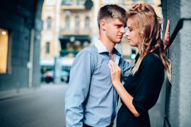 moda aşk hikayesi güzel genç kadın ve beyaz adam modeli sarışın, ayakta poz, mükemmel makyaj ve saç, siyah elbise, Klasik takım, poz, rötuş, vintage renkler ile