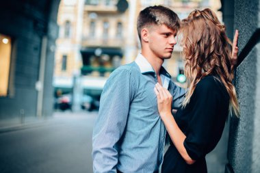 moda aşk hikayesi güzel genç kadın ve beyaz adam modeli sarışın, ayakta poz, mükemmel makyaj ve saç, siyah elbise, Klasik takım, poz, rötuş, vintage renkler ile