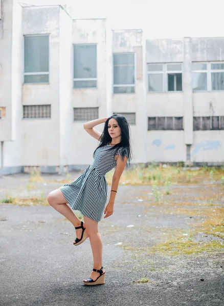 Sexy brünette schlanke Mädchen posiert in dem kurz entkleideten schwarz-weißen Kleid und High Heels — Stockfoto