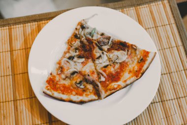 Tablo üzerinde iki lezzetli sıcak dilimlenmiş pizza Salam ile rustik pizza, kopya alanı ile mozzarella fesleğen üst görünümü. Domates ve zeytin ile cam masada iki pizza
