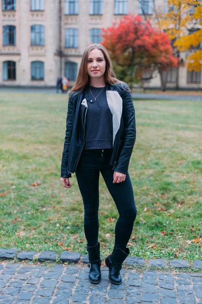 Porträtmode einer schönen blonden jungen kaukasischen Frau in einer schwarzen Pelzjacke kalte Herbstferien Frühling. Posieren neben dem Turm — Stockfoto