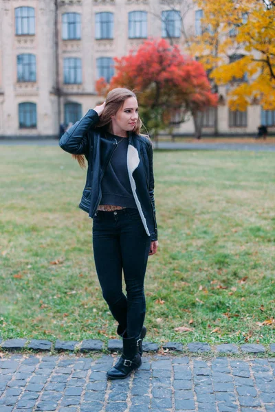 Módní portrét krásné blond mladé kavkazské ženy v černém kožešiny bunda studené podzimní pobyty jaro. pózuje vedle věže — Stock fotografie