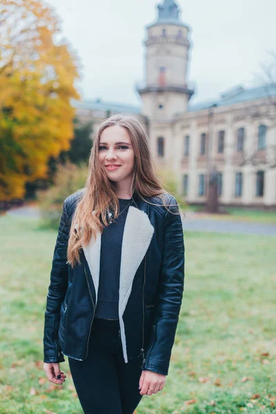 Porträtmode einer schönen blonden jungen kaukasischen Frau in einer schwarzen Pelzjacke kalte Herbstferien Frühling. Posieren neben dem Turm — Stockfoto