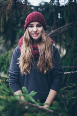 Güzel sarışın genç Kafkas kadın hipster moda köknar dallarında poz siyah kürk ceket portresi. Bordo kap ve eşarp. gülen saadettir gülümseyen