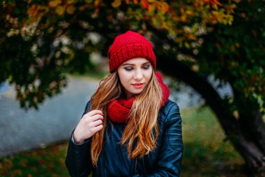 Güzel bir sarışın genç Kafkas kadın soğuk sonbahar kaçamakları bahar moda portre. sonbahar park, kırmızı yeşil sarı üç kere. Bordo kap ve eşarp. Utandım, rüya gibi güzel kız