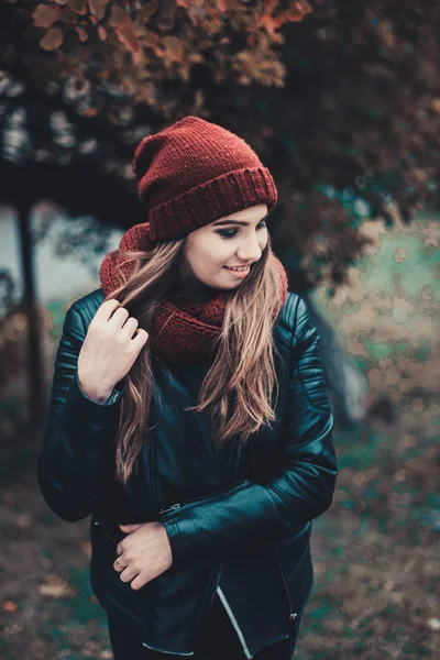 Portrait-Mode einer schönen blonden jungen kaukasischen Frau kalten Herbst Kurzurlaube Frühling. Herbstpark, rot grün gelb dreier. in weinroter Mütze und Schal. peinlich, verträumt schönes Mädchen — Stockfoto