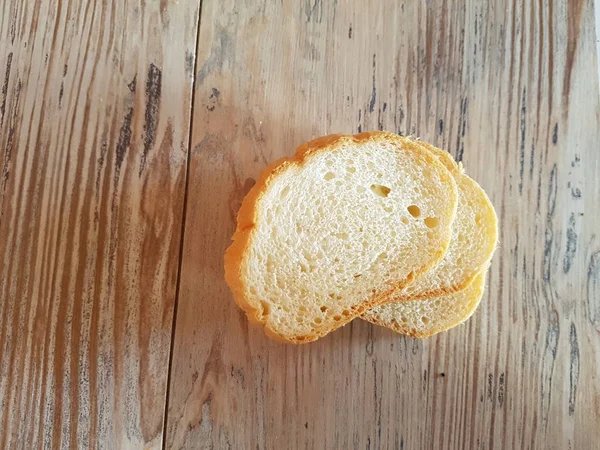 Tres rebanadas de baguette fresca sobre fondo de madera —  Fotos de Stock