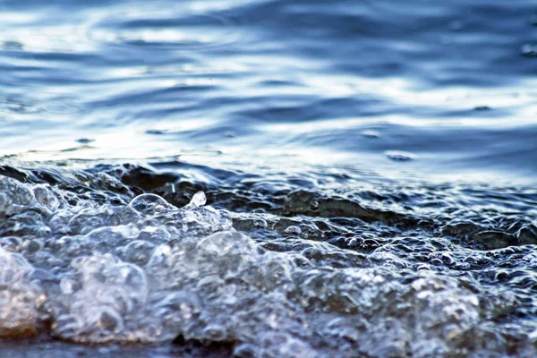 Primer plano de hermosas aguas azules rodando sobre la costa — Foto de Stock