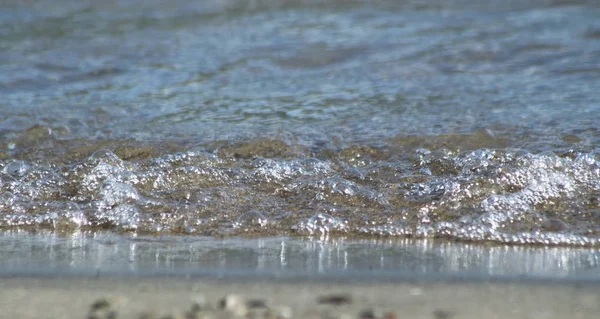 Voda vyhrnout na okraji pláže v úrovni očí — Stock fotografie