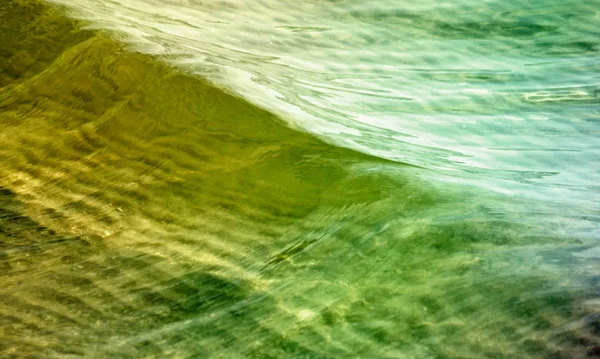 Águas com ondas suaves em verde e ouro — Fotografia de Stock