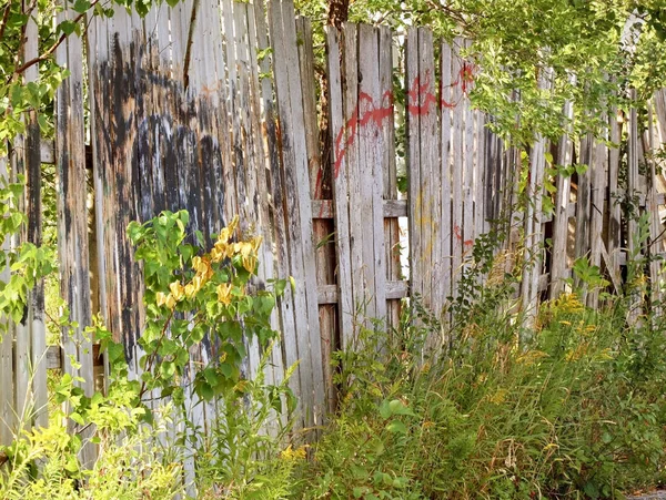 Old run down wooden fence with covered up painted Graffiti — Stock Photo, Image