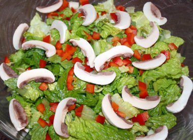 Romaine marulu, dilimlenmiş beyaz mantarlı ve doğranmış kırmızı biberli taze bahçe salatası.