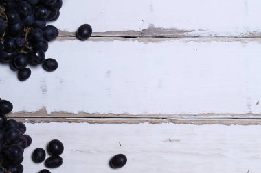 Tahta bir masanın üzerinde yatan üzüm