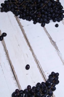 Tahta bir masanın üzerinde yatan üzüm