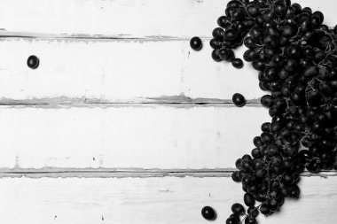 Tahta bir masanın üzerinde yatan üzüm