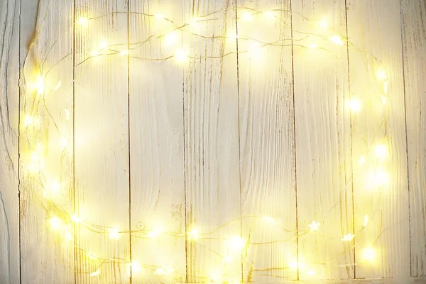 New Year background of bright garlands on a wooden