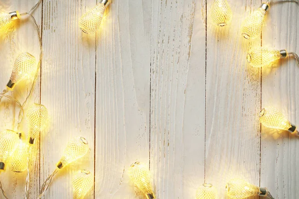 New Year background of bright garlands on a wooden