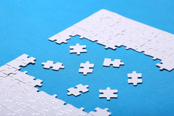 Szczegóły biały puzzle na niebieskim tle. Puzzle to pu — Zdjęcie stockowe