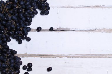 Tahta bir masanın üzerinde yatan üzüm