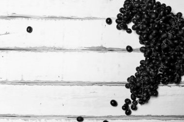 Tahta bir masanın üzerinde yatan üzüm