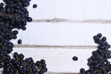 Tahta bir masanın üzerinde yatan üzüm