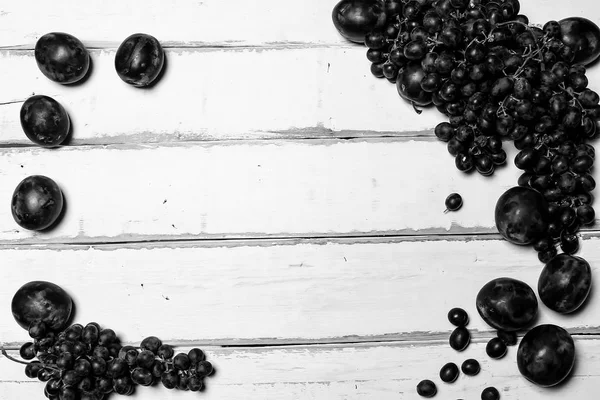 Чернослив и виноград на столе — стоковое фото