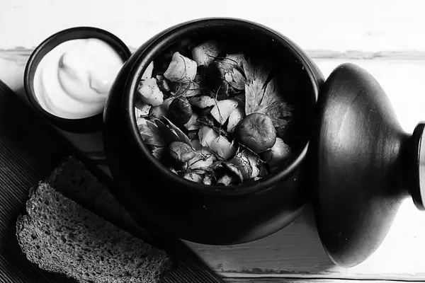 Batatas com cogumelos em um pote de barro. Cogumelos da floresta — Fotografia de Stock