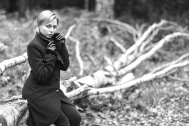 Kız sonbahar Park yürüyüş. Bir ağaçta oturuyor. Kız