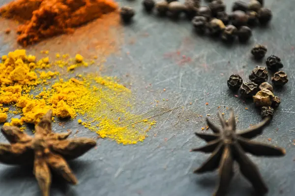 Oost-specerijen verspreid op een tafel thuis. Kurkuma en pe — Stockfoto