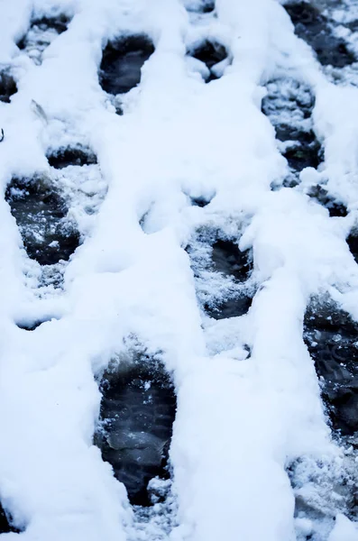 Грязные следы в снежную зиму. Трасса из сапог на колесах — стоковое фото