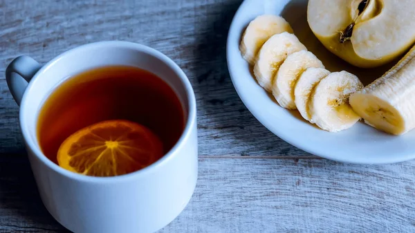 Chá com limão para o café da manhã. Uma bebida quente no — Fotografia de Stock