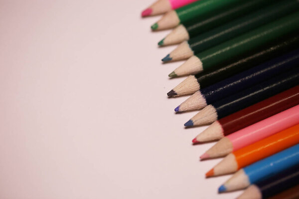 Multicolored pencils on the table. A stack of colored pencils ti
