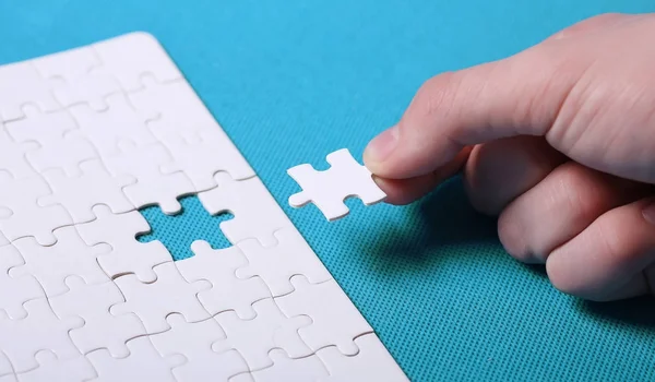 Szczegóły biały puzzle na zielonym tle. Puzzle jest puz — Zdjęcie stockowe