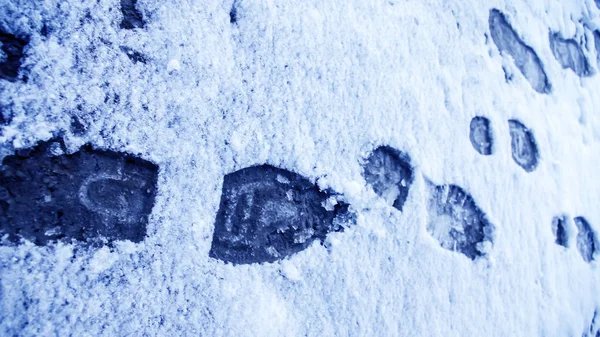 Грязные следы в снежную зиму. Трасса из сапог на колесах — стоковое фото