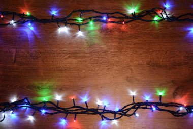 Ahşap arka plan üzerinde yeni yıl elektrik garland. Parlak Ampüller o