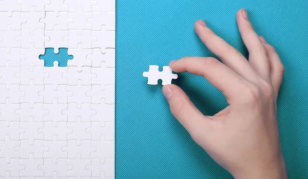 Szczegóły biały puzzle na zielonym tle. Puzzle jest puz — Zdjęcie stockowe