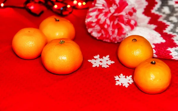 Christmas tree toys on a red napkin. Mandarins and candles on th — Stock Photo, Image