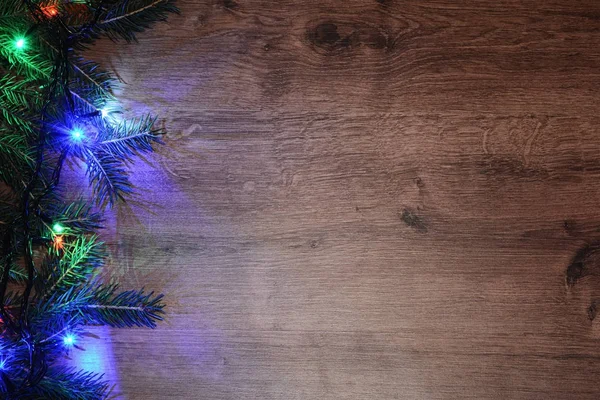 Новогодняя гирлянда на деревянном фоне. Яркие лампочки — стоковое фото