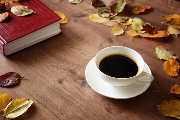 Objecten op een houten tafel een kopje koffie en een boek Stockfoto
