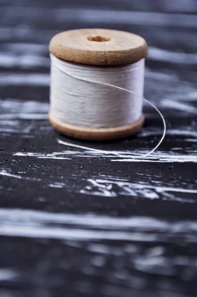 El carrete de hilo en la mesa. Hilo en un carrete para el arte. Ma. — Foto de Stock