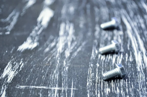 Nakrętki do naprawy leżącego na drewnianym stole. Nakrętki i śruby f żelaza — Zdjęcie stockowe